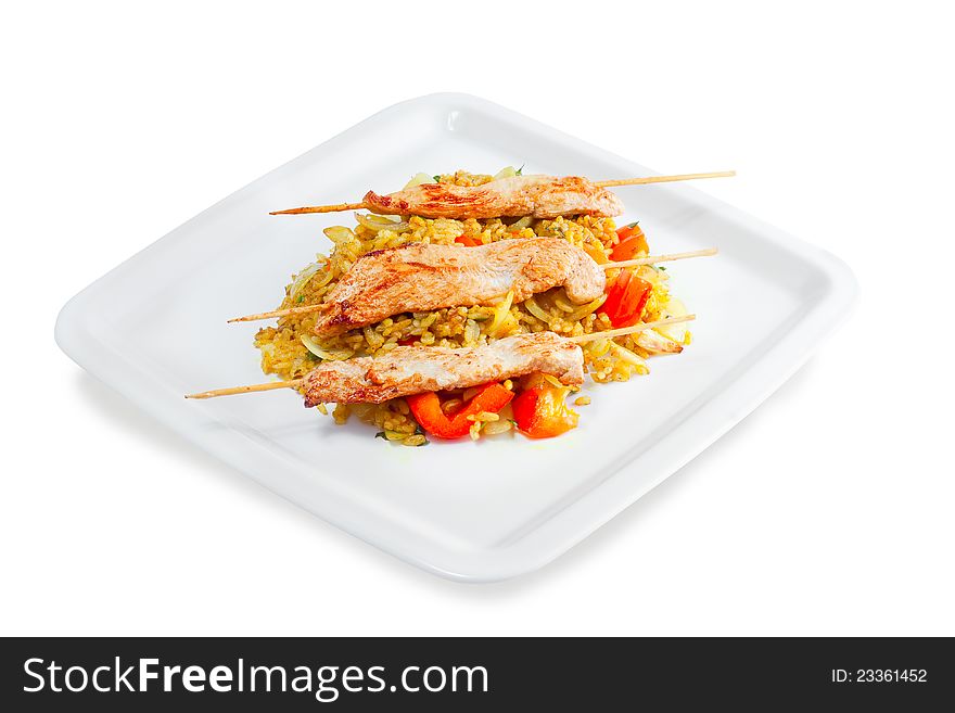 Kebab with rice and vegetables on a white background