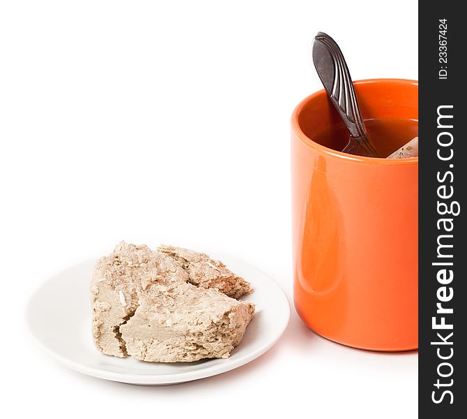 Orange cup of tea and halva on plate