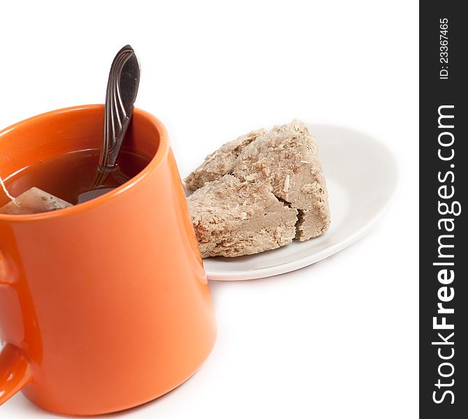 Orange cup of tea and halva on plate