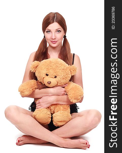 Cute young sexy girl in black underwear with a teddy bear over white background. Cute young sexy girl in black underwear with a teddy bear over white background