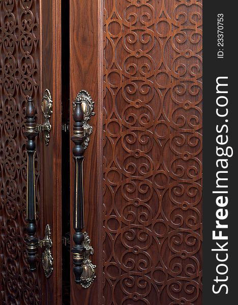 Handles on the old wooden door with carving. Handles on the old wooden door with carving