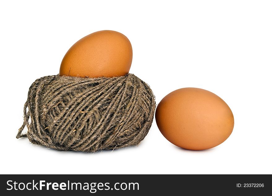 Two eggs on the white background, one of eggs lies in a nest