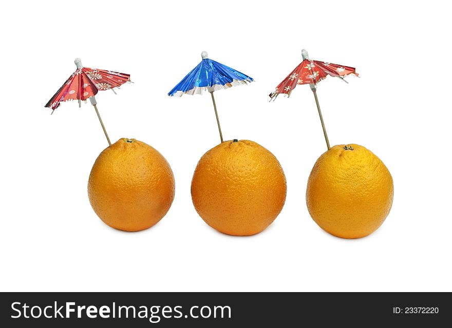 Three oranges with cocktail umbrellas