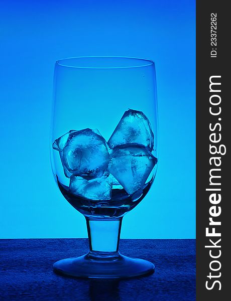 Glass for wine with ice crystals on a dark blue background