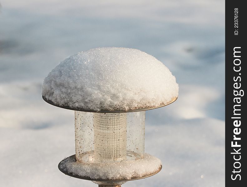 Street lamp under snow at sunny day, close-up