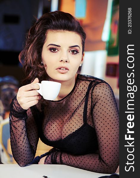 Charming sexy  woman in black clothes  sits at magnificent cafe  restaurant.