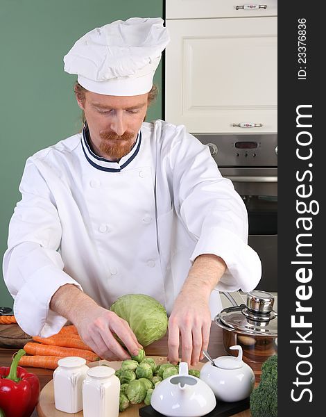 Young chef with vegetables, preparing lunch in kitchen. Young chef with vegetables, preparing lunch in kitchen