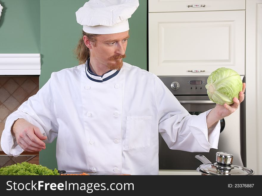 Young chef with cabbage, preparing lunch in kitchen. Young chef with cabbage, preparing lunch in kitchen