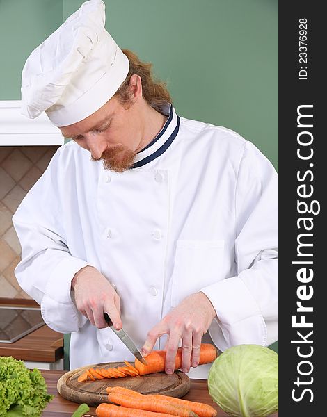 Young chef with carrot, preparing lunch in kitchen. Young chef with carrot, preparing lunch in kitchen