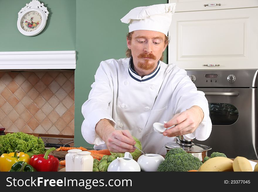 Young chef with vegetables, preparing lunch in kitchen. Young chef with vegetables, preparing lunch in kitchen