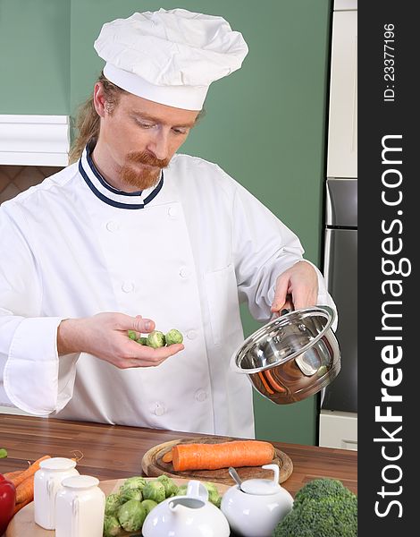 Young Chef with Brussels sprouts, preparing lunch in kitchen