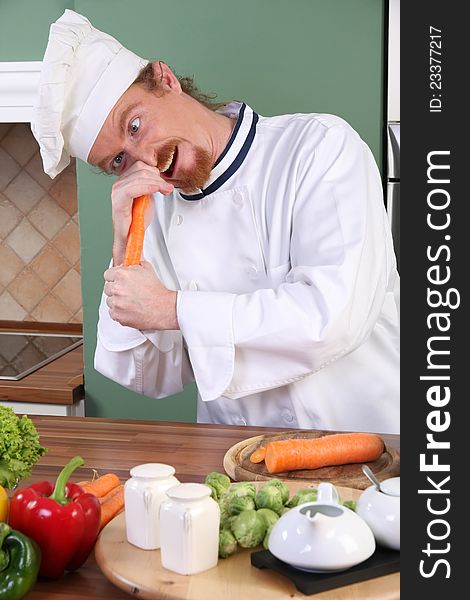 Funny young chef with carrot, preparing lunch in kitchen. Funny young chef with carrot, preparing lunch in kitchen