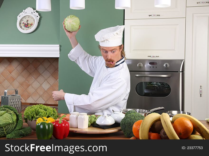 Young chef with cabbage, preparing lunch in kitchen. Young chef with cabbage, preparing lunch in kitchen