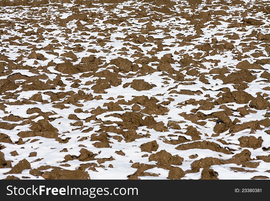 Agriculture land in winter covered with patches of snow creating an interesting background