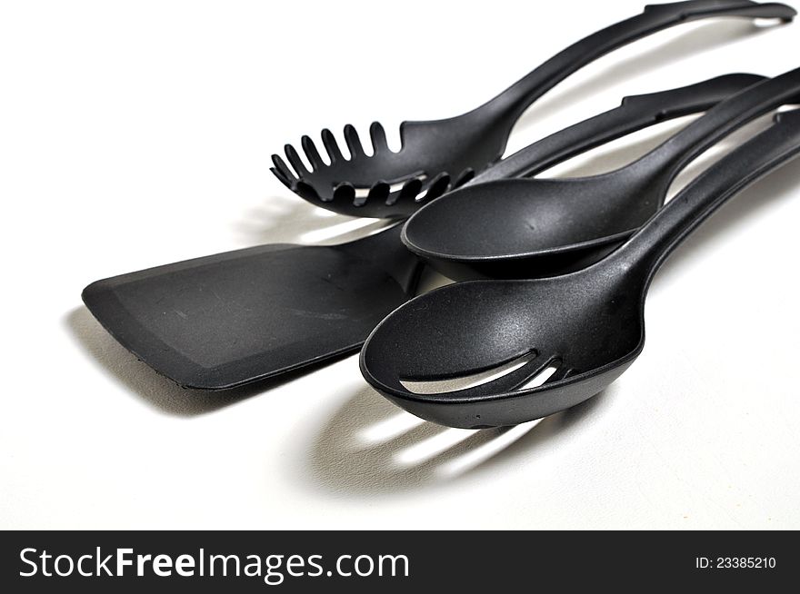 Four cooking utensil's are siting on a white background. A spatula, slotted spoon, a pasta spoon and a serving spoon. Four cooking utensil's are siting on a white background. A spatula, slotted spoon, a pasta spoon and a serving spoon.