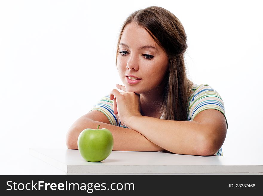 Portrait of a lovely young woman looking at fresh ripe apple and smiling  on white. Portrait of a lovely young woman looking at fresh ripe apple and smiling  on white