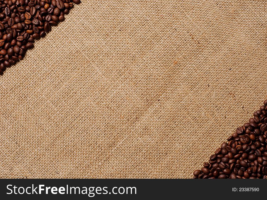 Burlap background with coffee beans in diagonal corners. Burlap background with coffee beans in diagonal corners.