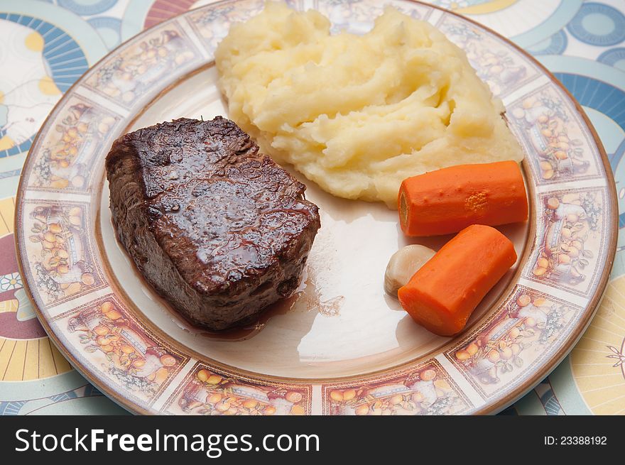 Meat with mashed potatoes and steamed carrot on the plate