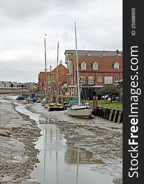 Photo of boats and yachts moored up on faversham creek at low tide. Photo of boats and yachts moored up on faversham creek at low tide.