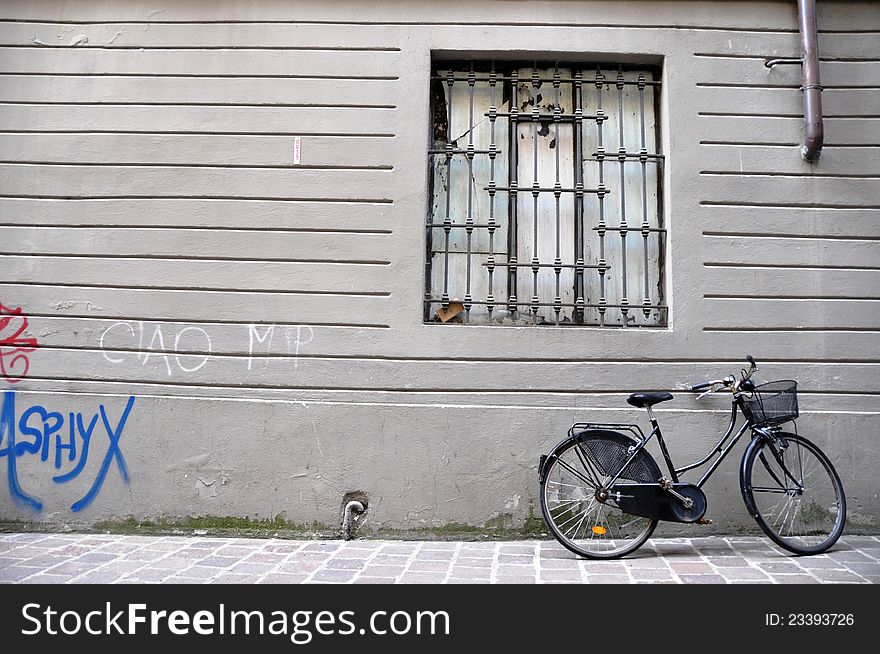 Bicycle parking in front of old wall with graffiti