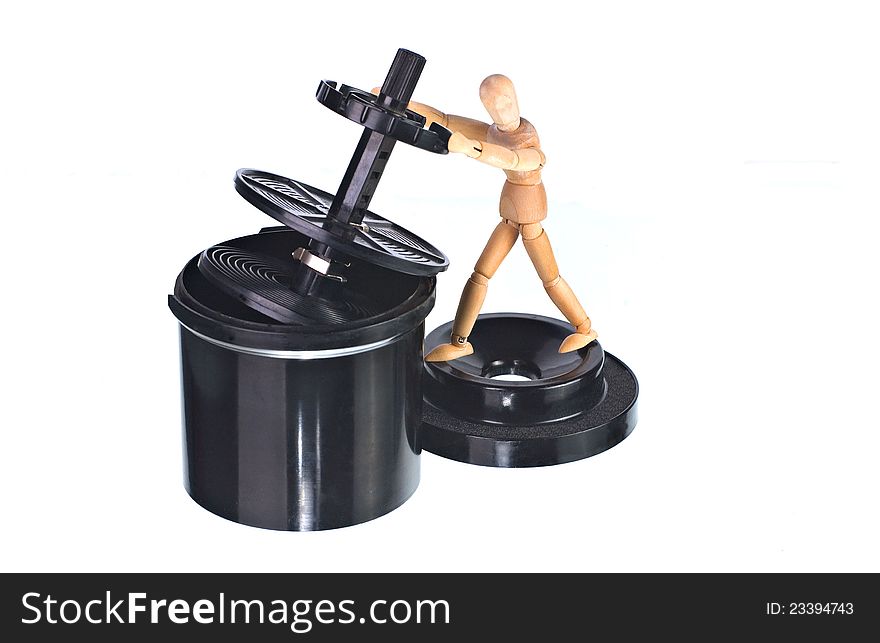 A black black plastic roll film developing tank with art doll isolated on white. A black black plastic roll film developing tank with art doll isolated on white