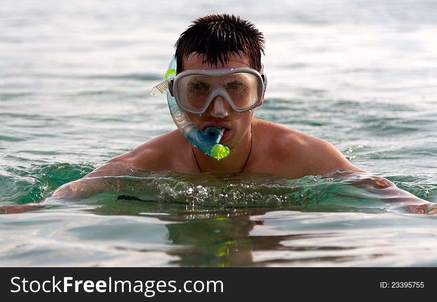 The man in the sea in a mask with a tube