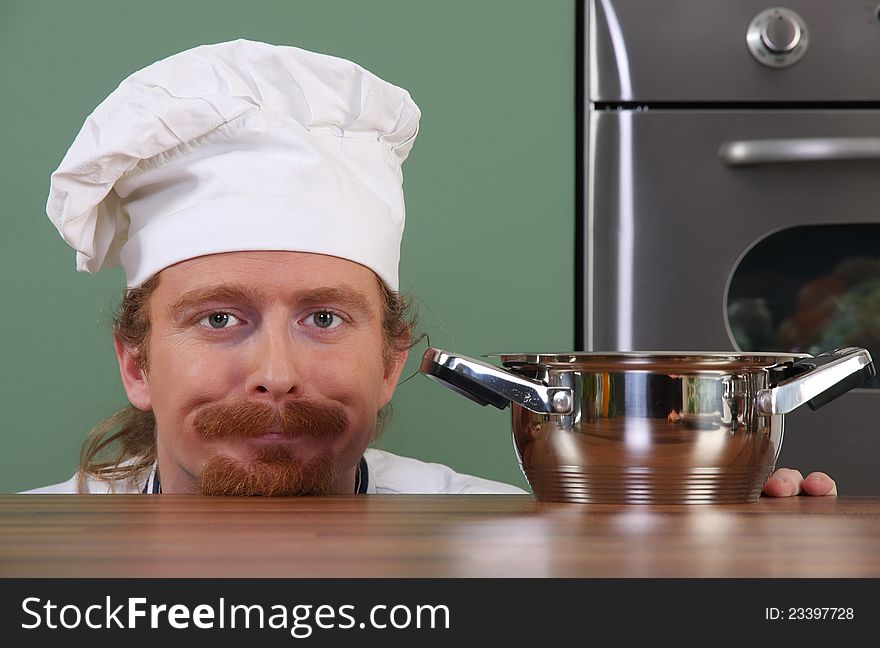 Funny young chef with a pot