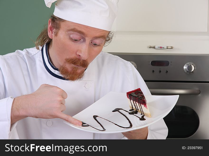 Funny young chef strange looking at piece of cake with chocolate sauce