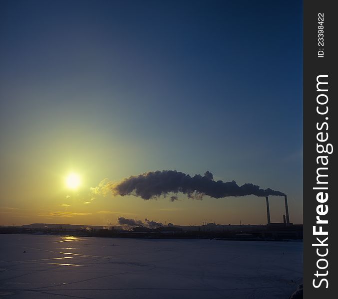 Winter landscape at sunset with two factory chimneys. Winter landscape at sunset with two factory chimneys.