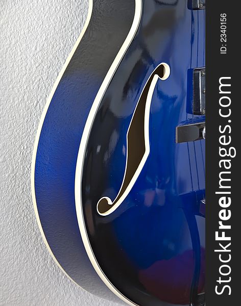 Left side detail and f-hole of blue electric jazz guitar. Left side detail and f-hole of blue electric jazz guitar