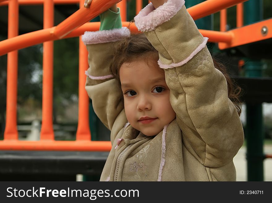 Girl Hanging From Monkey Bars