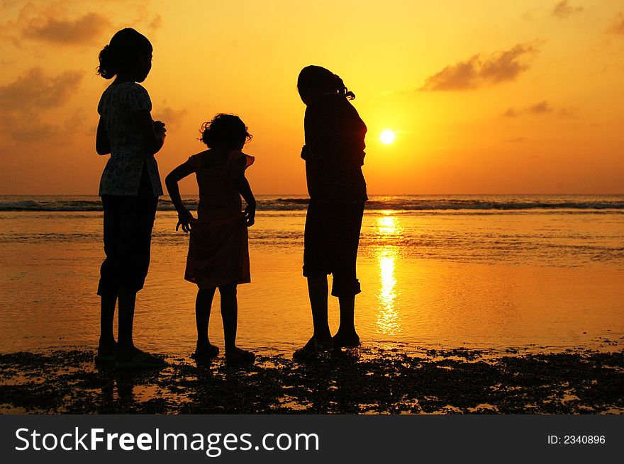 Reflection Silhouetted of three girls watching a boat moves at sunset. Reflection Silhouetted of three girls watching a boat moves at sunset.