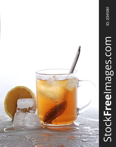 Cold tea, lemon and ice cubes melted in water