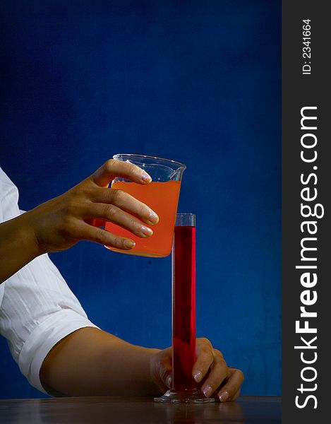 Beautiful female young scientist wearing glasses while doing a blood test