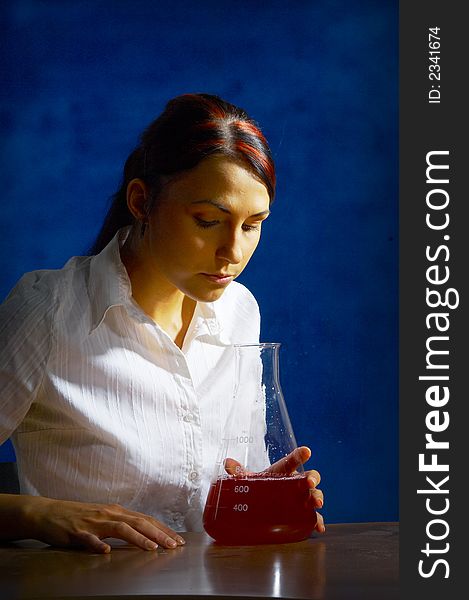 Beautiful female young scientist wearing glasses while doing a blood test