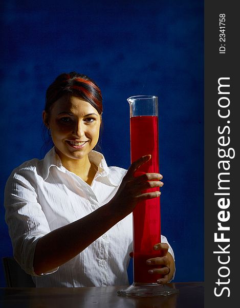 Beautiful female young scientist wearing glasses while doing a blood test