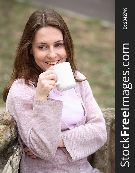 The girl holds a cup in hands and smiles. The girl holds a cup in hands and smiles