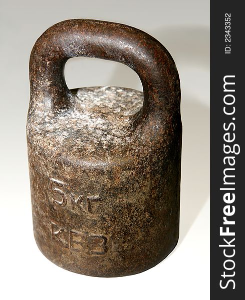 The old rusty metal weight of five kg. The old rusty metal weight of five kg.