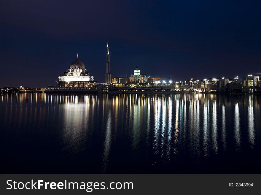 Night scene of a mosque bright lights reflected on the river