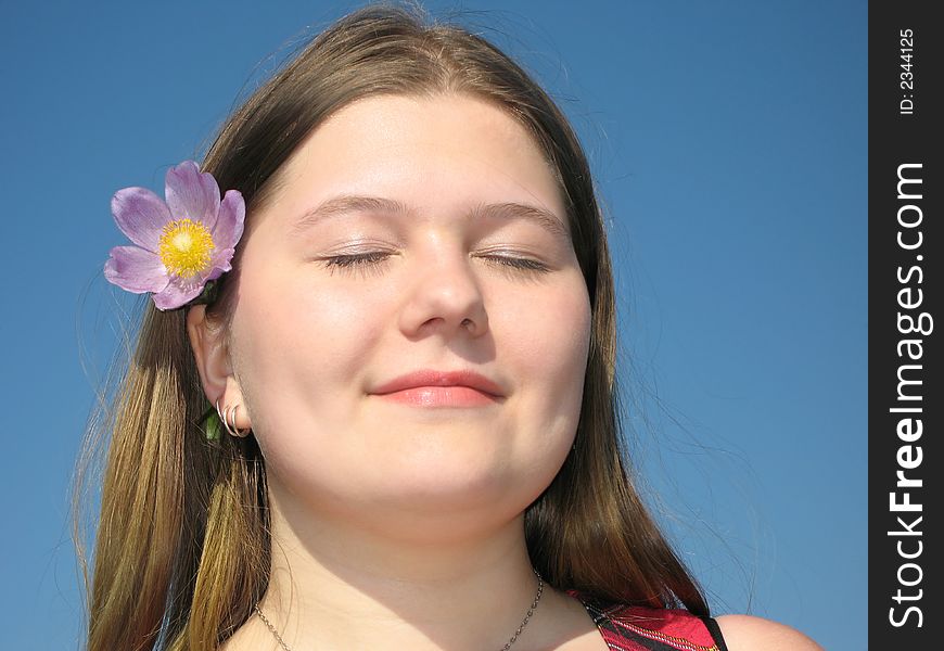 Pretty young girl with the flower in the hair