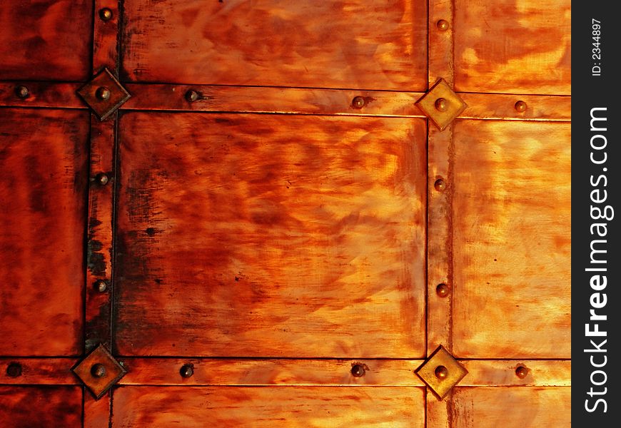 Coppery metal wall texture with rivets, background. Coppery metal wall texture with rivets, background