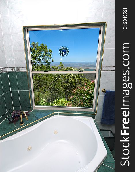 A bathroom with stunning views looking out over the township below. A bathroom with stunning views looking out over the township below