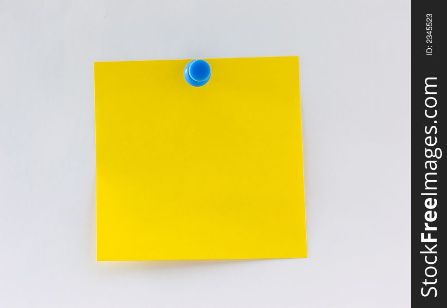 Blank yellow note pinned to a wall. Blank yellow note pinned to a wall