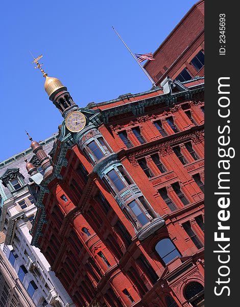 Tilted elegant office or apartment building with a clock and a small golden dome. Tilted elegant office or apartment building with a clock and a small golden dome.