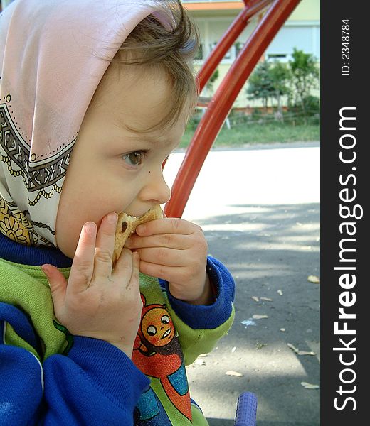Little girl is eating on the playground. Little girl is eating on the playground