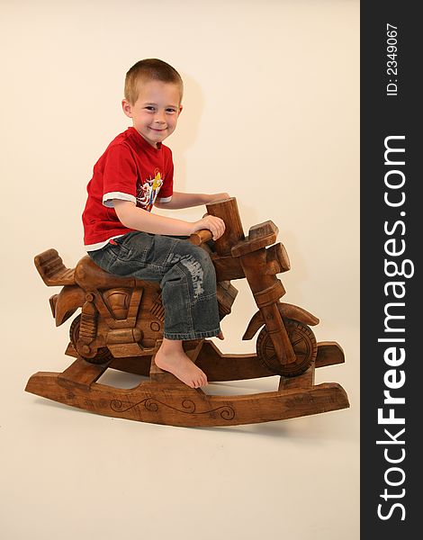 Young boy sat on a rocking motorbike. Young boy sat on a rocking motorbike