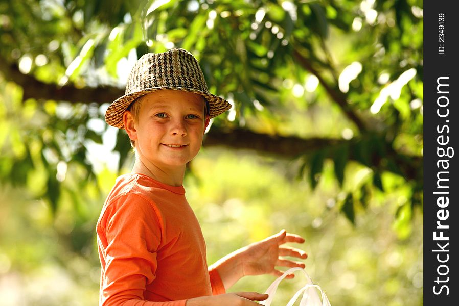 Young boy with old hat collect pecanuts. Young boy with old hat collect pecanuts