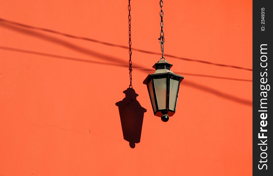 Lamp and shadow on an orange wall