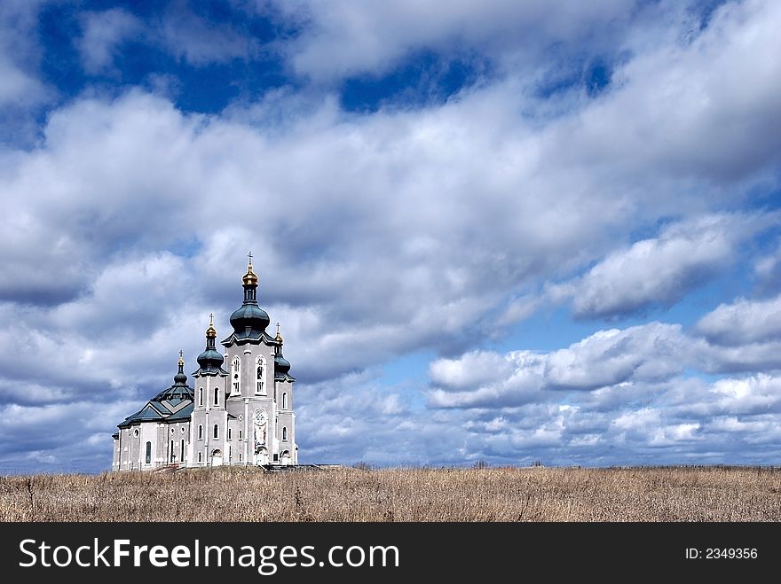 Big rural church/cathedral in field under dramatic cloudy sky. Big rural church/cathedral in field under dramatic cloudy sky