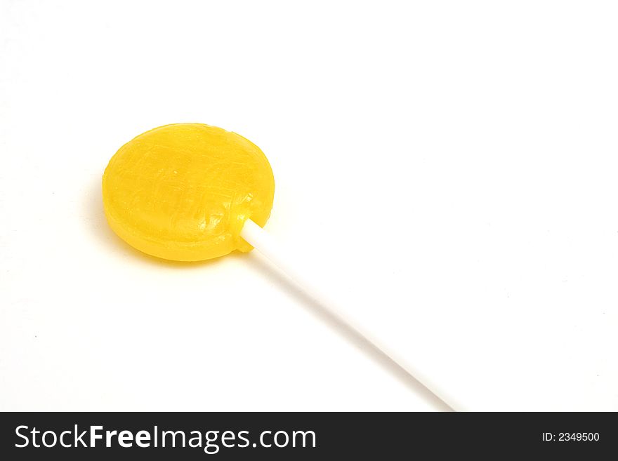 Picture of a yellow lollipop on white